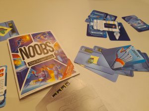 Spieleschachtel und Spielkarten des Kartenspiels Noobs im Weltraum